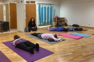 Restorative yoga with students completely supported by bolsters, blankets and props in deep relaxation